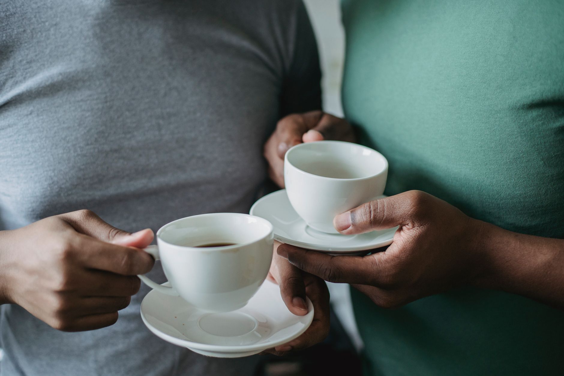 two people holding coffee cups